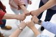 © New Africa - Unity concept. People holding fists together indoors, above view