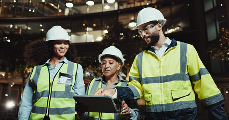 Aufkleber - People, construction worker and tablet with group in city for planning, review and happy with blueprint at night. Women, man and architect with touchscreen, app and building inspection in urban town