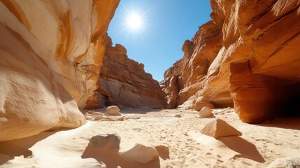 Poster - Deep canyon illuminated by the sun's rays with light sand and beige rock formations under a clear blue sky