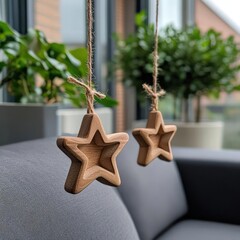 Poster - Wooden star ornaments hanging from strings with blurred background featuring green plants and a gray sofa creating a warm indoor scene