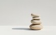 © creatfive - Stack of four light beige porous stones on a white surface, cast shadow, minimalist, zen-like setting