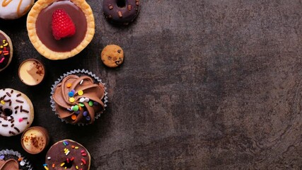 Leinwandbilder - Variety of sweet desserts. Above view, stop motion timelapse video on a dark stone background.