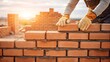 © Mobasser - Bricklayer constructing brick wall on construction site