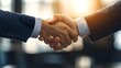 © Ytnart - Two business professionals shake hands in a modern office setting, symbolizing partnership and collaboration. The warm light creates a professional and welcoming atmosphere.