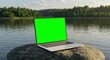 © Manji - Laptop on Rock by Lake with Green Screen for Mockup Insert
