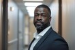 © NikoG - Portrait of a confident black man in office hallway