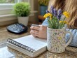 © Ata - Woman writing, flowers, home office