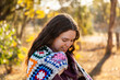 © Austockphoto - Female adult outside in winter with crochet blanket around shoulders