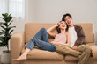 © Chanakon - Happy moment of asian family man and woman husband and wife just married buying new house. Relax on sofa in living room