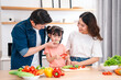 © Q88 - Family preparing a healthy meal in the kitchen with fresh vegetables and bonding time together