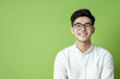 © Dararat - Confident Asian man smiling in casual attire against green background