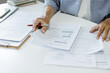 © Lek - asian man work at gome reading business document and checking contract before apply for loan and start owner business