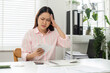 © wichayada - Home Office and Budget Anxiety. A woman feels overwhelmed while assessing her financial documents at home, juggling responsibilities.