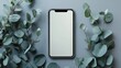 © Ghiska - Modern smartphone surrounded by eucalyptus leaves on a muted gray surface