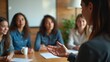 © Delta Amphule - Diverse group of women engaging in a collaborative meeting or discussion around a table.