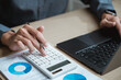 © Garun Studios - Accountant used a calculator financial analysis managing payroll tax accounting budget accounts.