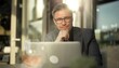 © nyul - Business portrait - Businessman working with laptop computer outdoor. Man sitting on office terrace in sunlight, thinking, smiling.