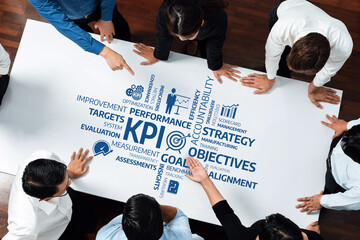 Aufkleber - A dynamic team engages in a collaborative strategy session, pointing at key performance indicators and objectives displayed on a large sheet, fostering innovation and teamwork. Amity