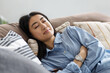 © kucherav - Young asian woman relaxing on cozy couch