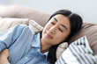 © kucherav - Young asian woman relaxing on cozy couch