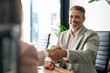 © insta_photos - Happy mature business man bank manager or lawyer handshaking client at office meeting. Smiling professional businessman and businesswoman shake hands having partnership agreement with handshake.