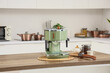 © Pixel-Shot - Modern green coffee machine with jar of beans on table in kitchen