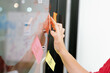 © InfiniteFlow - Closeup of professional businesswoman hand put and stick the colorful sticky notes on whiteboard while presenting business plan. Creative business meeting and brainstorming concept. Immaculate.