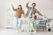 © Pixel-Shot - Happy parents with their little daughter in headphones and microphones singing karaoke at home
