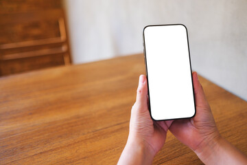 Wall Mural - mockup image of a woman holding black mobile phone with blank desktop screen