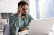 © fizkes - Tired annoyed Latin businessman touching head at laptop, reading or watching about problem, mistake, error, bad news, using computer at office workplace, thinking about trouble, feeling overworked
