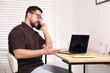 © New Africa - Stock exchange. Man talking on smartphone at desk indoors