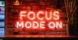 © antishock - Thick neon sign focus mode on in red and gold tones glowing thick font above bricks with subtle cables and ambient shadows