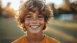 © AiPhotoSale - Curly-haired boy beams at the camera, bathed in soft light. A joyful portrait with a blurred, dreamy background