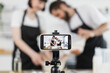 © sofiko14 - Caucasian parents and child, dressed in aprons, knead dough for video blog in home setting. Emphasizes modern content creation, family collaboration, and homemade culinary activities