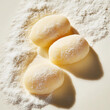 © ANGELINA - Soft cream dumplings gnocchi dusted with flour on a light background. Italian food. Isolated. Top down view