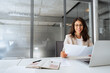 © Stock 4 You - Smiling latin business woman saleswoman working on laptop computer reading financial contract document in office workplace. Young manager businesswoman specialist doing paperwork using pc. Copy space