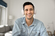 © fizkes - Smiling Hispanic man wear wireless headphones looking at camera record videovlog, take part in videoconference event by business. Social media icon portrait, vlogging, digital communication using app
