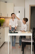© ADDICTIVE STOCK - Mother and son enjoying playful cooking in modern kitchen