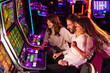 © Dragana Gordic - Group of Friends Enjoying Slot Machines in a Lively Casino Environment