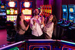 © Dragana Gordic - Friends Laughing Together While Enjoying Slot Machines at a Casino