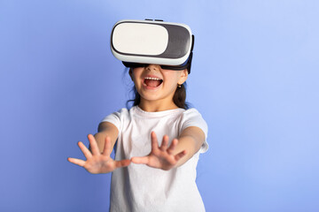 Leinwandbilder - Excited korean child using VR headset and experiencing virtual reality, blue studio background