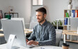 © Prostock-studio - Cheerful middle aged businessman sitting at worktable at office, typing on computer keyboard, chatting with business partners or working on marketing research