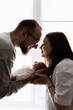 © Ananass - Portrait of a young family with infant in his arms photographed on a light window background.