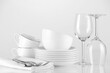 © New Africa - Different clean dishware and cutlery on light background