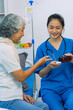 © ArLawKa - Asian female doctor consulting elderly patient at home, explaining diagnosis and treatment plan, providing health care to elderly woman, medical health concept