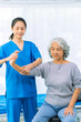 © ArLawKa - Elderly woman receives medical services from home care nurse while performing muscle strengthening exercises.