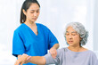 © ArLawKa - Elderly woman receives medical services from home care nurse while performing muscle strengthening exercises.