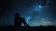 © Nat - A woman is sitting on the grass and looking up at the stars