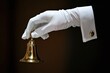 © Elena - Hand in white glove ringing golden bell. Concierge service and luxury hotel call for help. Premium quality accommodation business assistance on call concept.