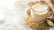 © CHAIYAPHON - A glass of creamy plant-based milk sits beside a scatte of quinoa and peanuts on a textured surface.